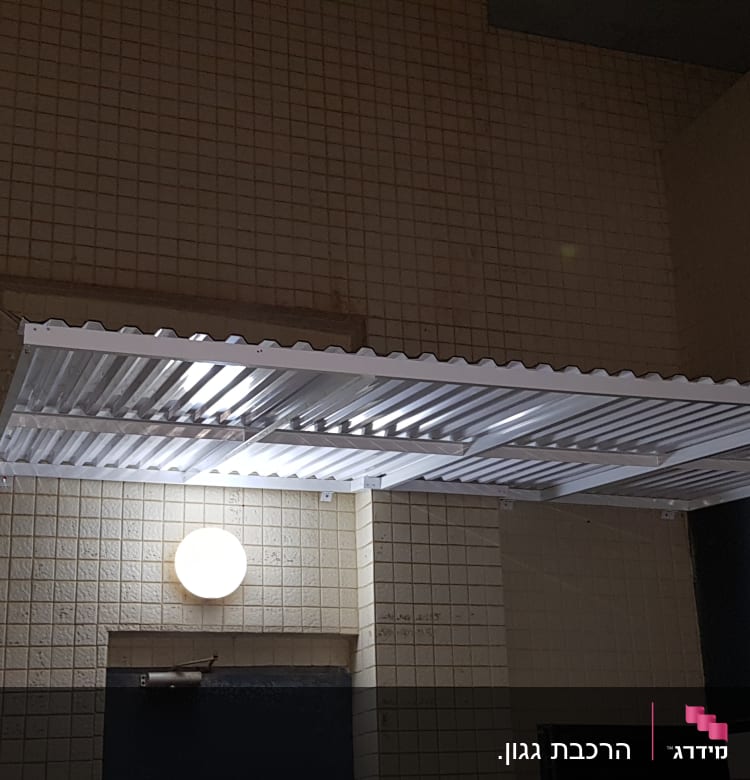 גגון אלומיניום מותקן על קיר חיצוני